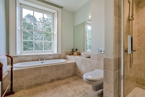 Ein Badezimmer mit Badewanne, Toilette und Duschbereich.