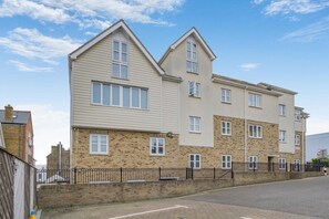 A multi-story residential building with a brick facade, multiple windows, and a flat roof. - 2 Bed in Broadstairs (oc-b39035) (Broadstairs)