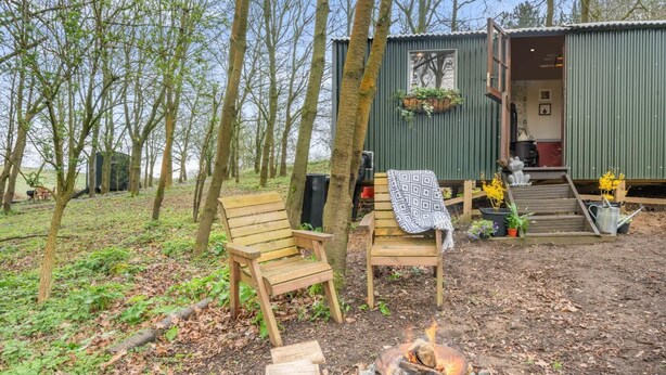 A rustic cabin with a fire pit, wooden chairs, and a bench. - 1 Bed in Edgefield (oc-h39008) (Edgefield)