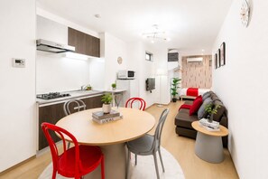 A modern, compact living space with a kitchen, dining area, and a sofa. - New Construction | Right Next to Asakusa and the Skytree! | Sleeps 5 | 6-minute walk from the station | 26 ㎡ | High-speed Wi-Fi | 3 beds | (墨田区)