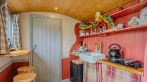 A compact kitchen with a sink, kettle, and wooden stools. - 1 Bed in Edgefield (oc-c39014) (Edgefield)