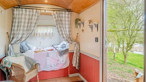 A bedroom with a bed, curtains, a window, and a view of a tree and grass. - 1 Bed in Edgefield (oc-c39014) (Edgefield)