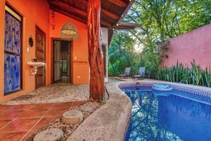A pool area with a stone pathway leading to a door, surrounded by tropical plants and a large tree. - Tropical Pool Oasis Steps From Beach, Shops, Cafès (Sámara)