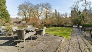 A patio with wicker furniture and a stone pathway leading to a gate. - 2 Bed in Skelwith Bridge (oc-lr128) (Skelwith)