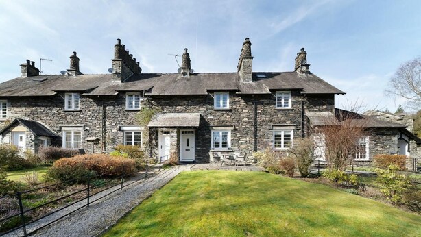 A stone building with multiple chimneys, a central door, and a well-maintained lawn. - 2 Bed in Skelwith Bridge (oc-lr128) (Skelwith)