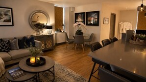 Uma sala de estar moderna com sofá, mesa de centro e área de jantar.