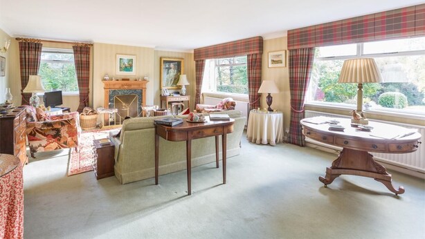 A traditional living room with a fireplace, a sofa, a table, and a television. - 3 Bed in Tomatin (oc-ca211) (Inverbrough)