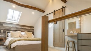 Un dormitorio con cama, escritorio y ventana grande.