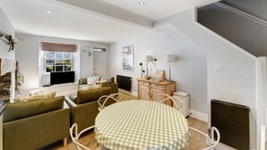 A modern living room with a dining table, sofas, and a kitchen area. - 2 Bed in Ambleside (oc-lr002) (Ambleside)