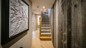 A hallway with a wooden wall, a staircase, and a framed map on the wall. - 3 Bed in Windermere (oc-lr235) (Windermere)