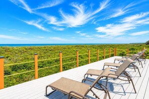 A deck with sun loungers overlooking a beach. - Near Beach Condo w/ Pool · Hot Tub · Pickleball (Hilton Head Island)