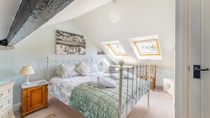 A bedroom with a bed, bedside tables, a dresser, a painting, and skylights. - 3 Bed in Ambleside (oc-lr030) (Ambleside)