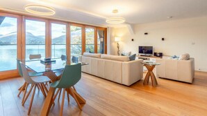 Un salon moderne avec une table à manger en verre, un canapé et un téléviseur.