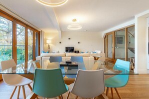 Ein modernes Wohnzimmer mit einem Glastisch, einer Couch und einem Fernseher.