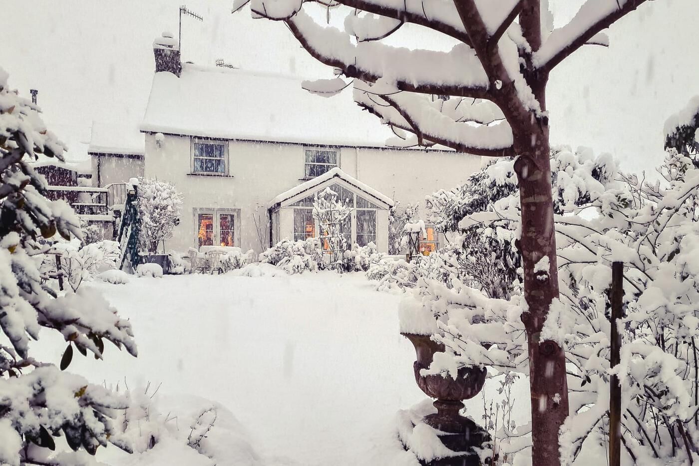 A snow-covered house with a visible front door and windows.