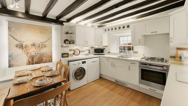 A kitchen with white cabinets, a washing machine, a microwave, and a stove. - 3 Bed in Chapel Stile (oc-lr202) (Chapel Stile)