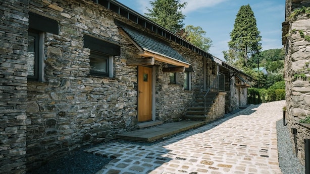 A stone building with a wooden door, windows, and a staircase leading to a second level. - 1 Bed in Windermere (oc-lr225) (Windermere)