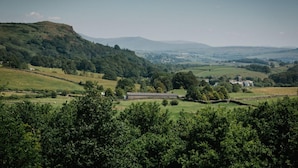 A rural landscape with rolling hills, a stone wall, and a small building. - 1 Bed in Windermere (oc-lr225) (Windermere)