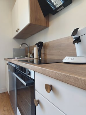 A modern kitchen with wooden countertops, a built-in oven, and a coffee machine. - New! Terra and Ocean - 1-minute walk to the sea (Ault)
