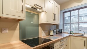 Eine moderne Küche mit integriertem Induktionskochfeld, einer Mikrowelle und einem Toaster.