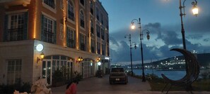 A building with a large entrance, a car parked in front, and a body of water in the background. - Star Bay Boutique Hotel Phu Quoc  (Phu Quoc)