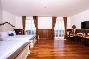 Una habitación de hotel con una cama grande, un escritorio con espejo y un televisor.