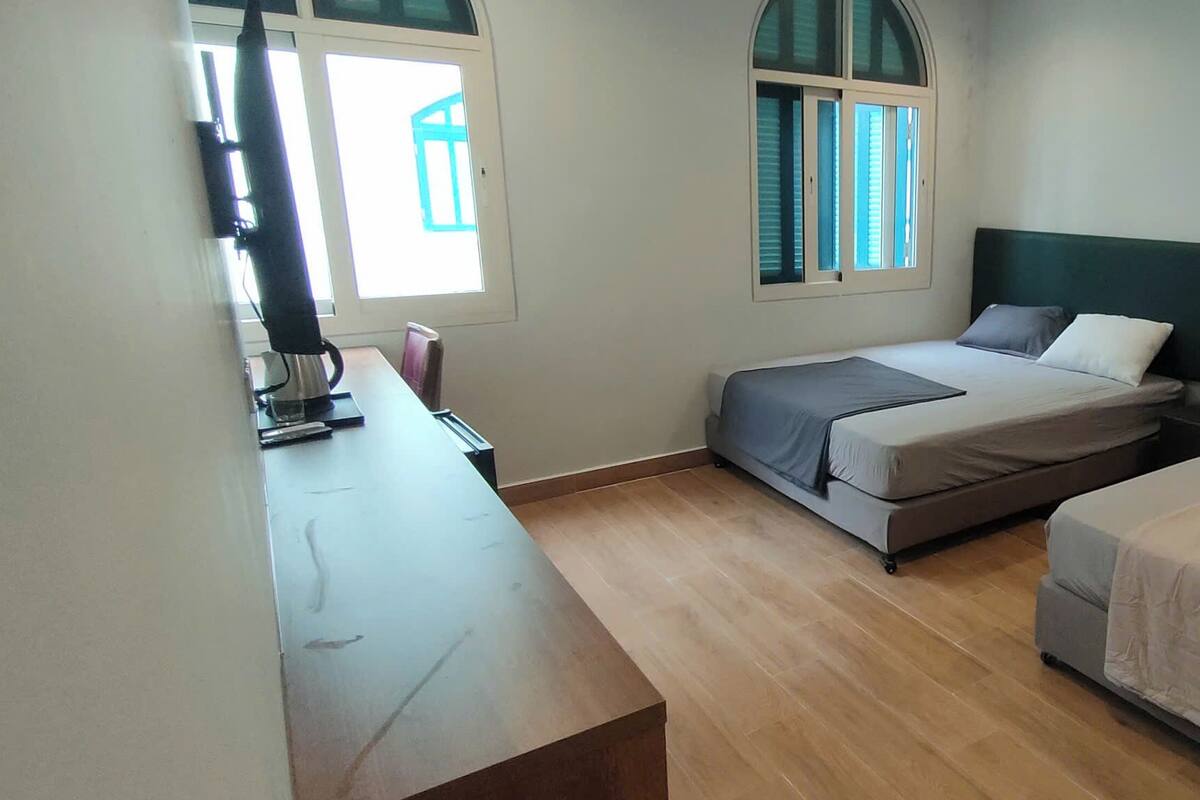 A room with a bed, a desk, and a window.