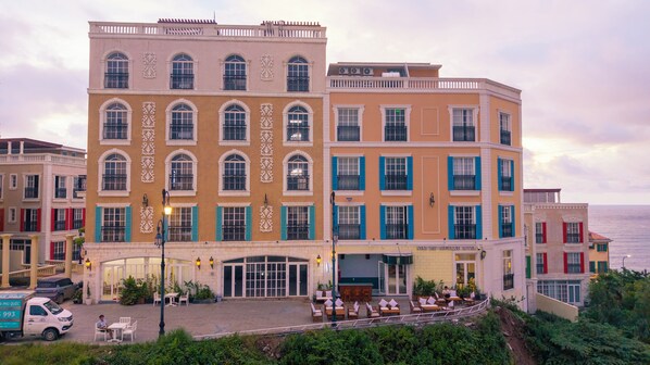 Un hotel de varios pisos con restaurante en la planta baja y terraza al aire libre.