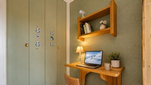 A room with a desk, chair, laptop, lamp, and a shelf with books and a plant. - Mont-Vallon (Les Allues)