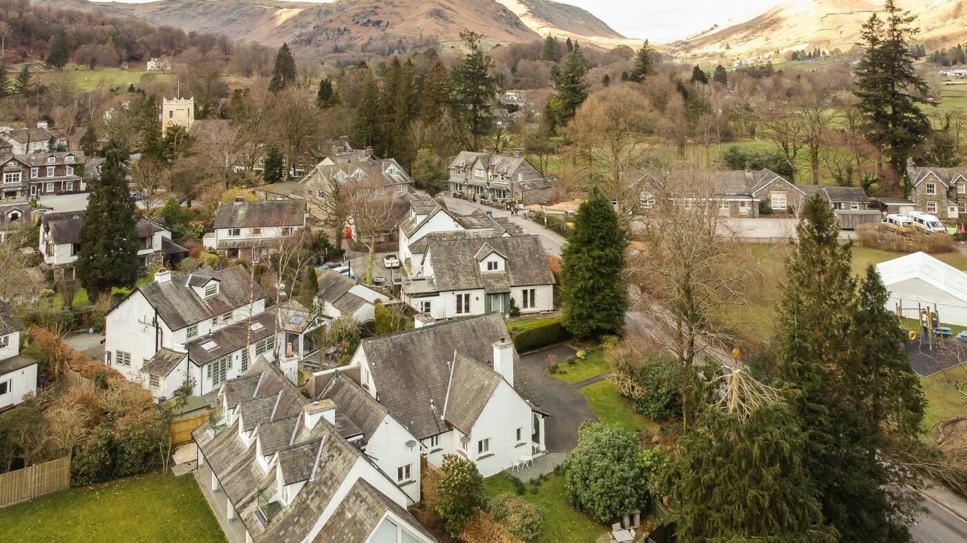 Zona residencial com casas, um castelo e montanhas ao fundo.