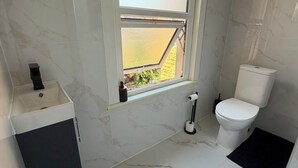 Un bagno con il water, un lavandino e una finestra.