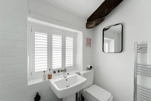 A bathroom with a white sink, toilet, and window with blinds. - 2 Bed in Keswick (oc-lr181) (Keswick)