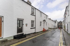A narrow street lined with white buildings, a visible door, and a sign indicating a cottage. - 2 Bed in Keswick (oc-lr181) (Keswick)