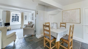 A spacious living area with a dining table, chairs, a sofa, and a television. - 3 Bed in Ambleside (oc-lr121) (Ambleside)