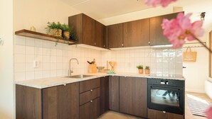 Una cucina con mobili in legno, forno incassato e un piano di lavoro.