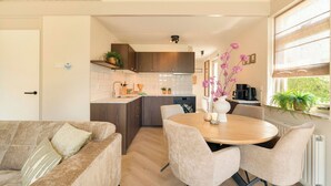 Una cucina moderna con zona pranzo, mobili in legno e una finestra vista panoramica.