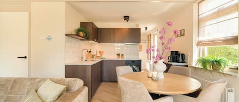 Une cuisine moderne avec un coin repas, des meubles en bois et une fenêtre offrant une belle vue.