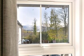 A window with a view of a residential area, including houses and trees. - 1 Bed in Portinscale (oc-lr185) (Portinscale)