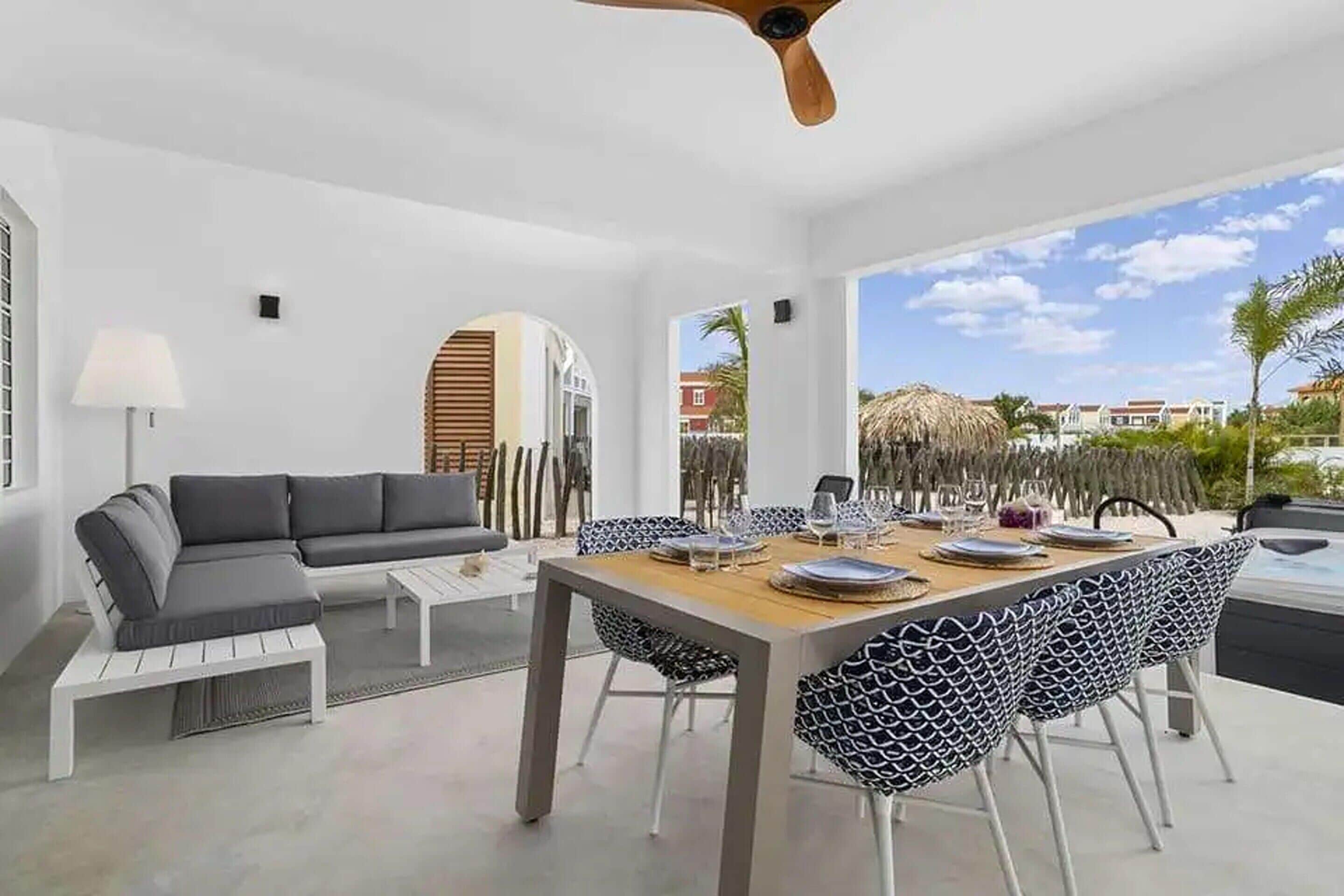 Un espace repas moderne avec une table en bois dressée pour quatre personnes, entourée de chaises à motifs.