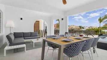 A modern dining area with a wooden table set for four, surrounded by patterned chairs.
