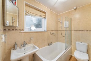 A bathroom with a bathtub, a sink, a toilet, and a window with a curtain. - 2 Bed in Keswick (oc-lr147) (Keswick)