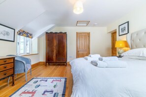 Ein Schlafzimmer mit einem Bett, einem Schreibtisch, einem Kleiderschrank und einem Fenster mit Blick.
