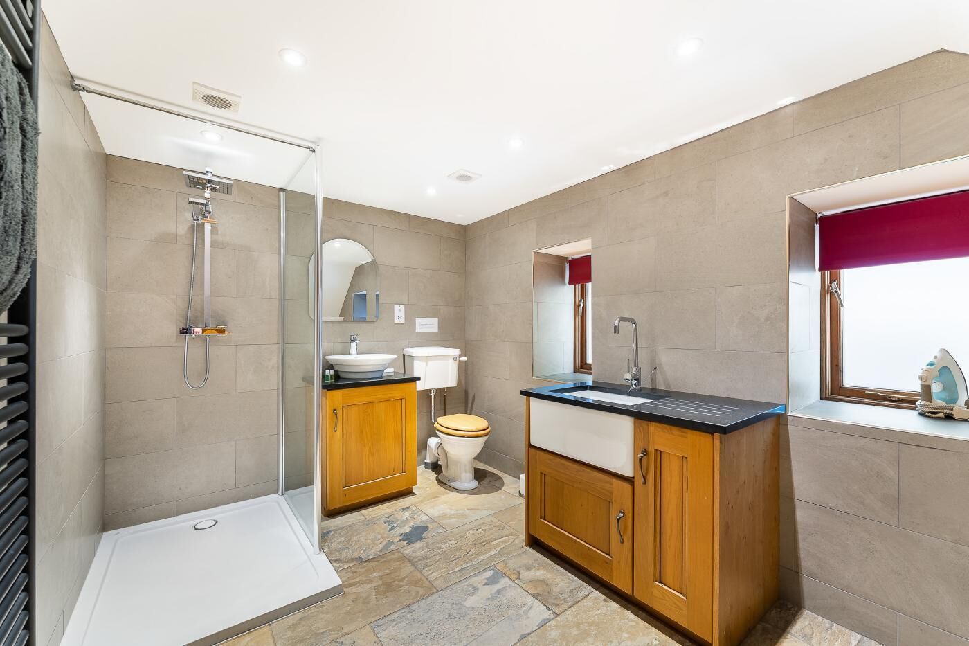Een moderne badkamer met douche, toilet, wastafel en badkamerkast.