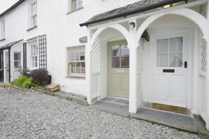 A white building with a covered porch, a door, and a window. - 1 Bed in Hawkshead (oc-lr067) (Hawkshead)