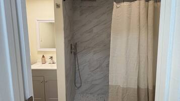 A bathroom with a shower, toilet, and sink.