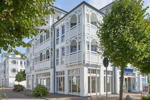 Un immeuble à plusieurs étages, doté de balcons, de grandes fenêtres et surplombant un ciel dégagé.