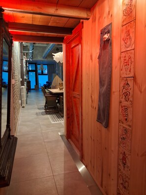 A corridor with a wooden door, a table with chairs, and a radiator. - LIROLA ARTISTIC LOFT (Granada)