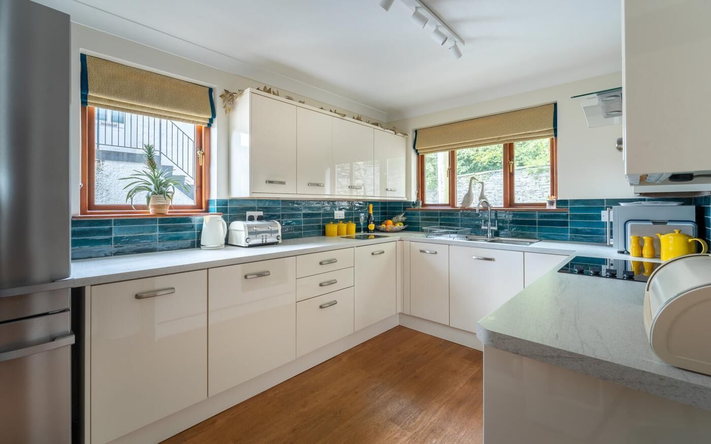 Une cuisine moderne avec des meubles blancs, un plan de travail en bois et un four encastré.