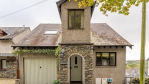A stone building with a green door, a small window, and a garage. - 4 Bed in Ambleside (oc-lr054) (Ambleside)