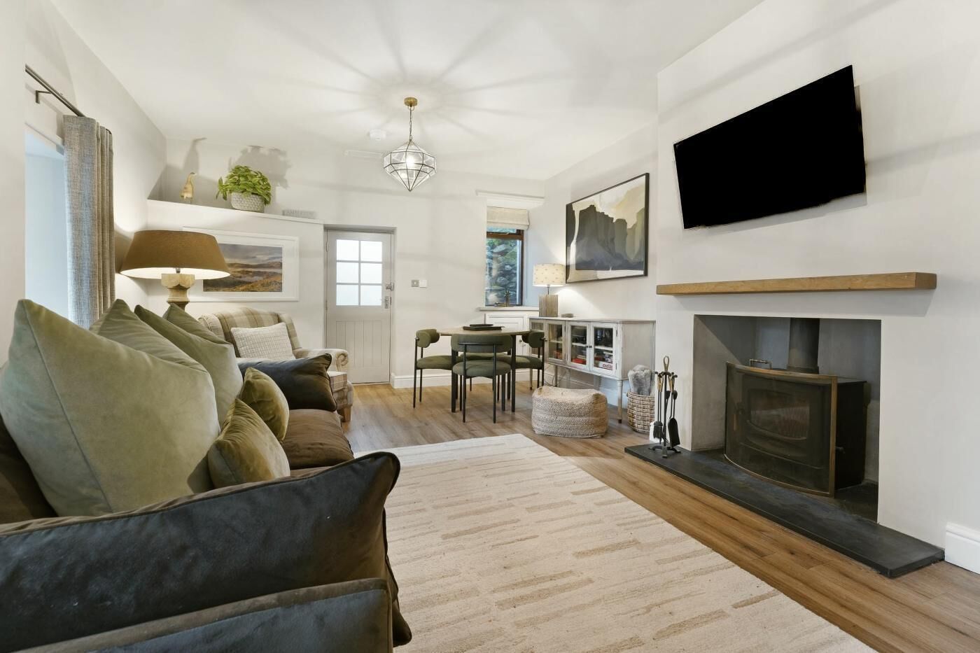 A living room with a sofa, fireplace, TV, and a dining area.